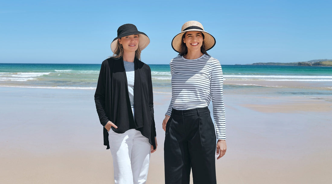 Two women standing on a beach in Solbari UPF 50+ sun hats and sun protective clothing.