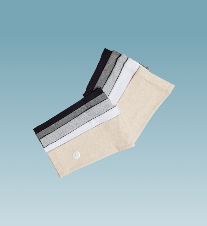 Solbari arm sleeves in four colours floating on a light blue background.